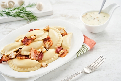Dumplings with potato and mushrooms in cheese sauce