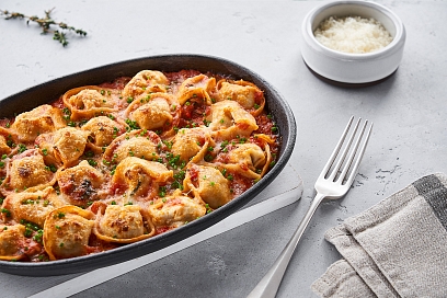 Dumplings in tomato sauce with cheese crust